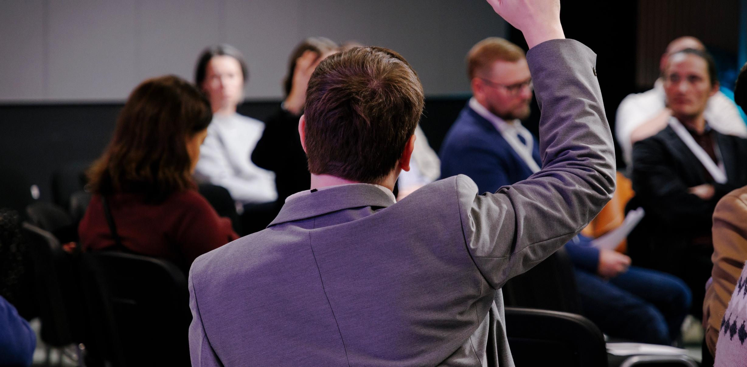 Участник поднимает руку на дискуссии CulturalistTalks. (Osallistuja nostaa kätensä CulturalistTalks-keskustelussa.)