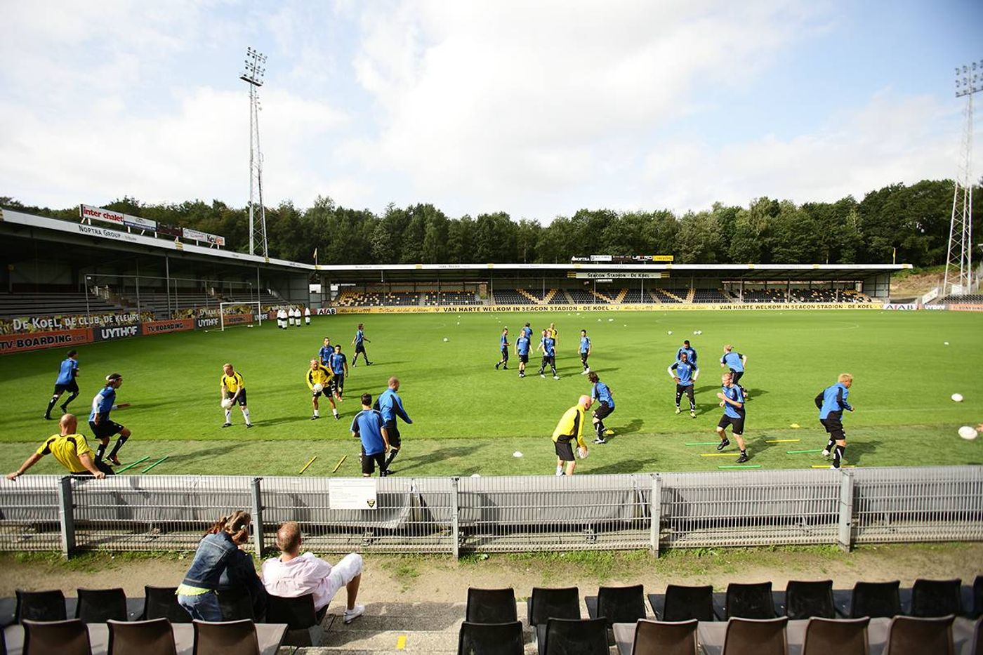 Football coaches running a training session with players