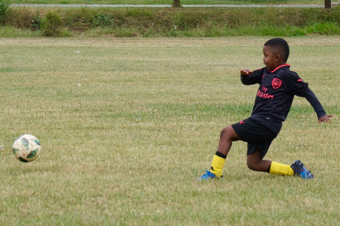 A young Kenyan player kicking a football