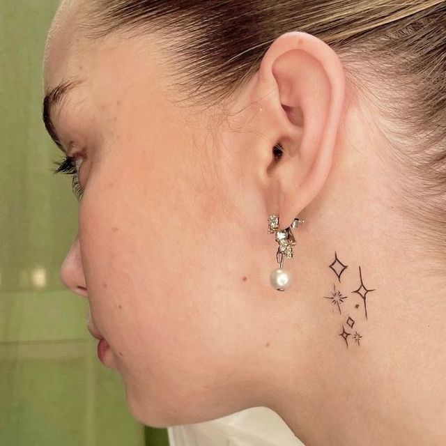 stars on neck behind ear tattoo