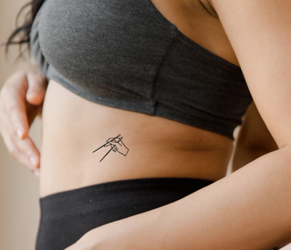 chopsticks tattoo on waist