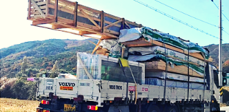 This image shows the "Day Zero" of a kit home project: Delivery and Logistics.