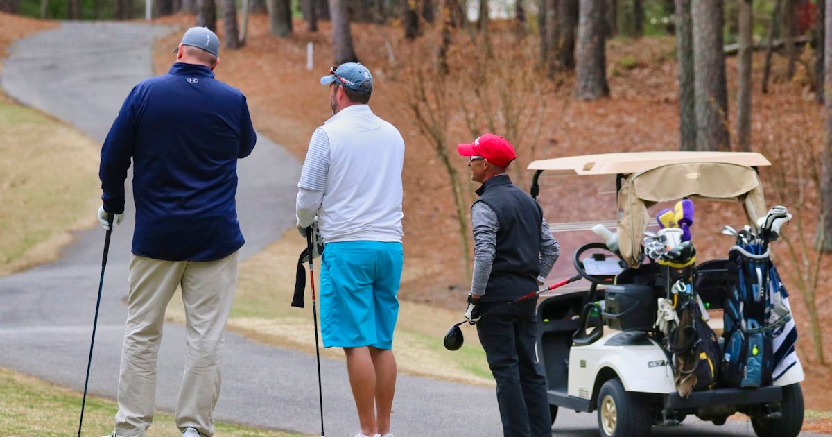 Business team riding a golf cart together on the course