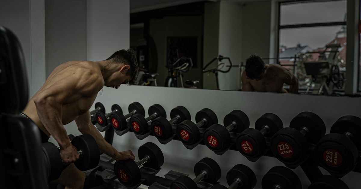 Athlete selecting a dumbbell in a gym before a fitness training session