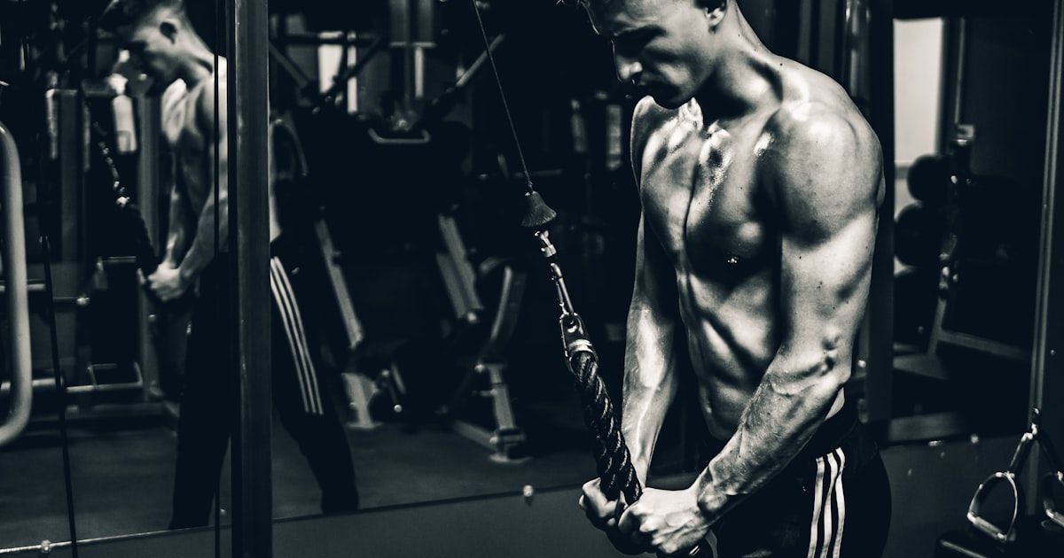 Golfer performing dumbbell exercises in a gym to build swing power and consistency