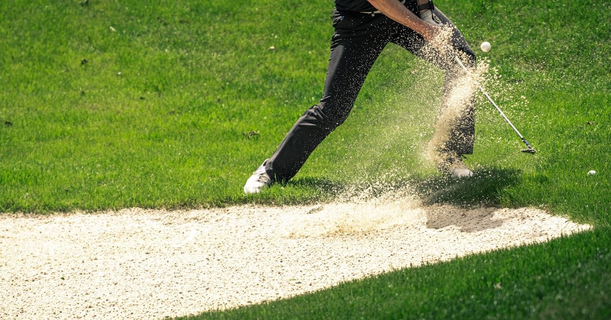 Golfer mid-swing on the course demonstrating sport-specific movement
