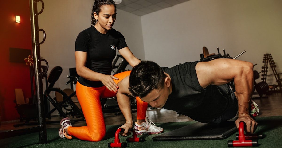 Coach working with an athlete on movement training in a modern fitness facility