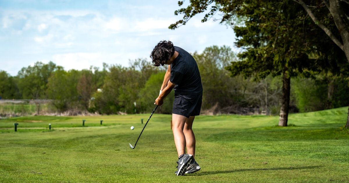 Golfer at full follow-through on a sunny course