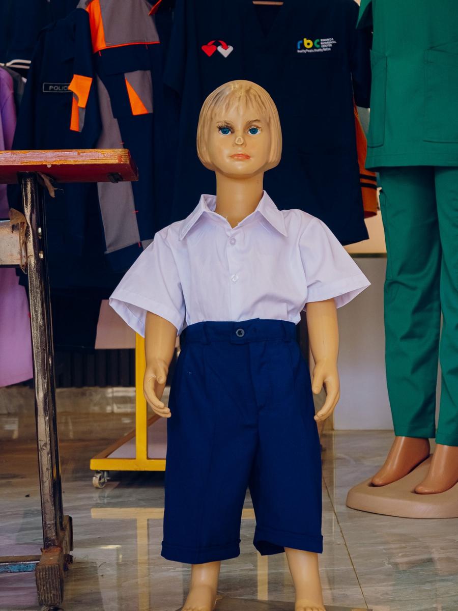 School uniform displayed in the DIKAM showroom, with institutional uniforms behind