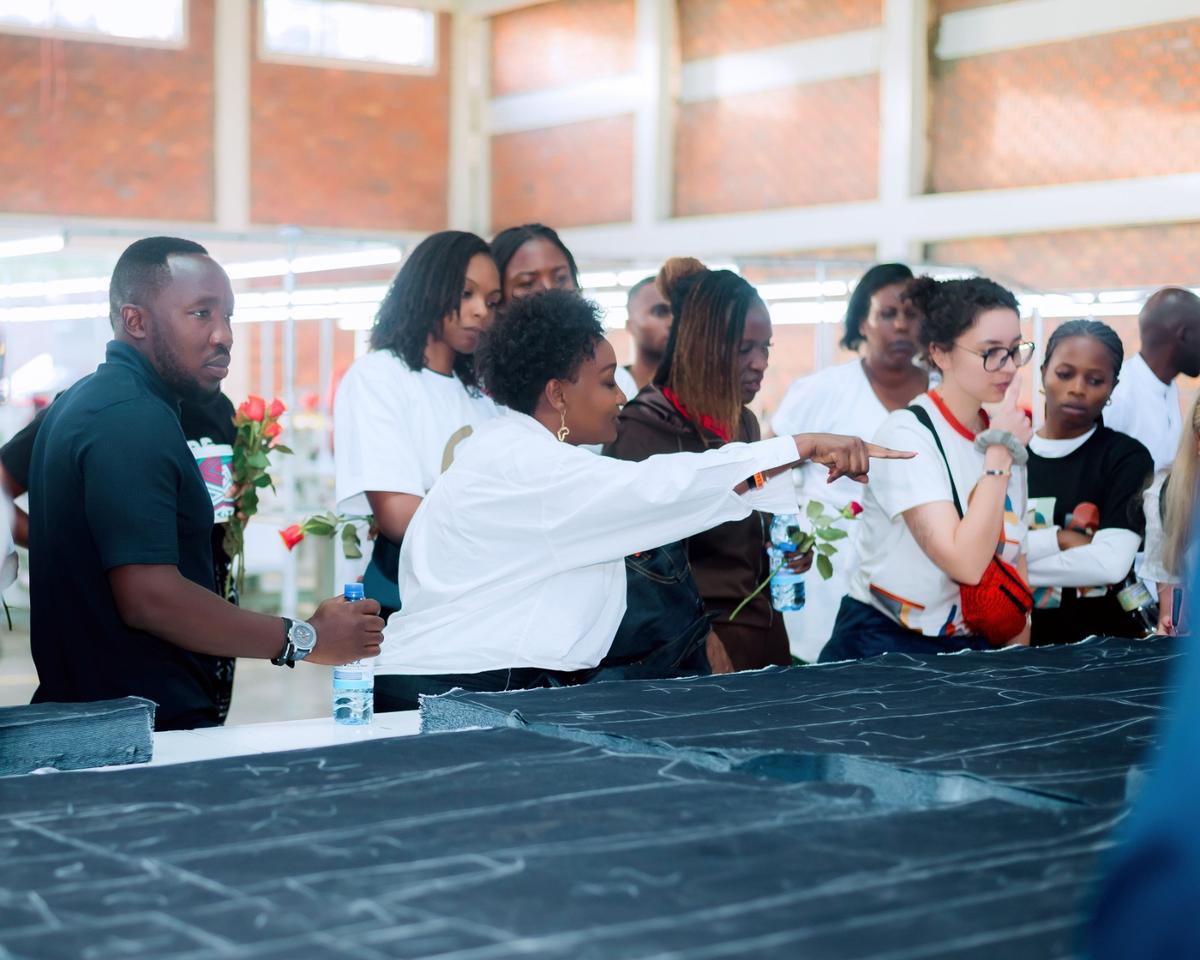 A DIKAM cutting table spread with marked fabric, with staff checking the layout