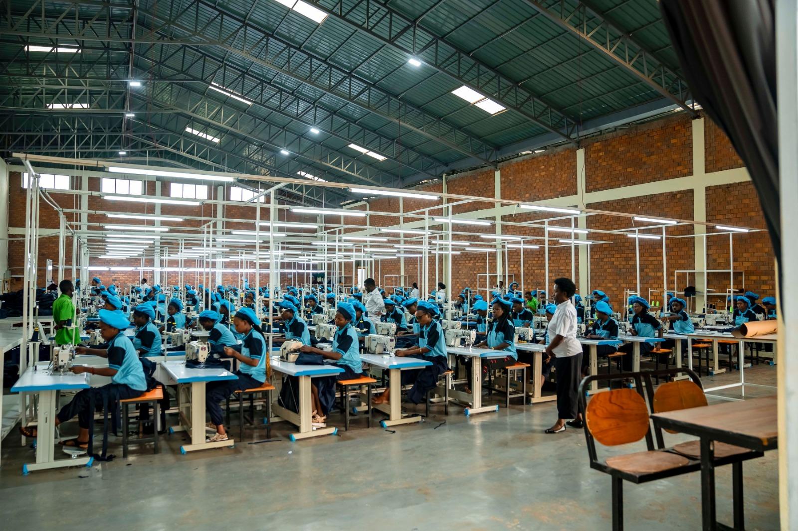 The DIKAM production hall in Kigali — rows of machinists in blue uniforms at their sewing stations