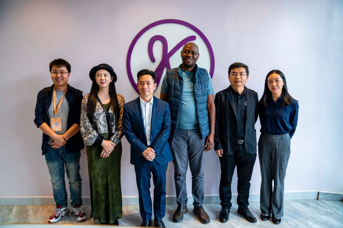 Sun Lijun and delegation with a DIKAM host in front of the DIKAM monogram in the showroom