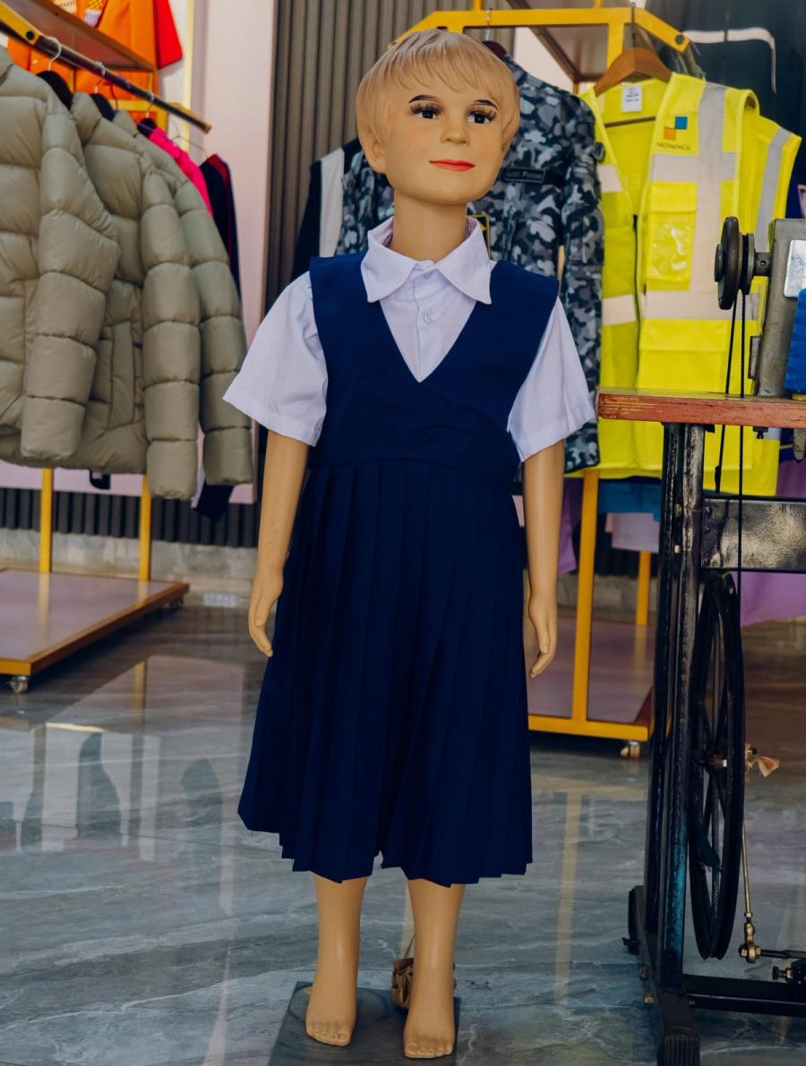 A children's pinafore school uniform in the DIKAM showroom