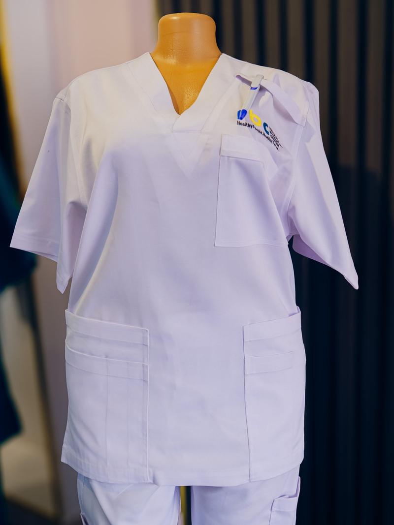 White medical scrubs sewn at DIKAM, on a mannequin in the showroom