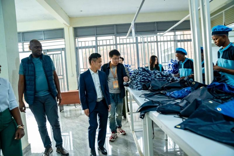Sun Lijun of Alibaba tours the DIKAM production floor, where machinists in blue uniforms finish drawstring bags