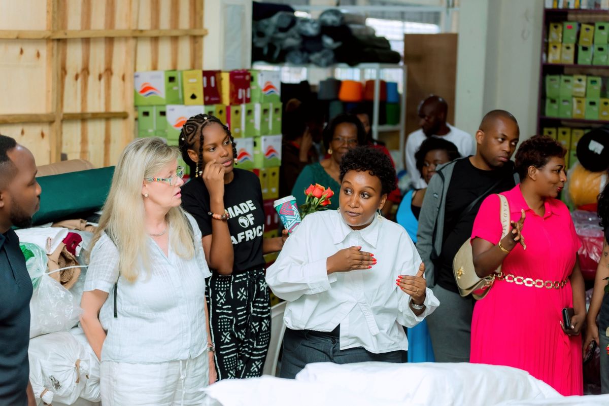Diane Mukasahaha shows the DIKAM fabric store to visiting members of the ABH community