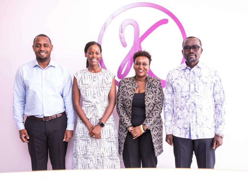 Guests and DIKAM leadership in front of the DIKAM monogram during the ministerial visit to the showroom