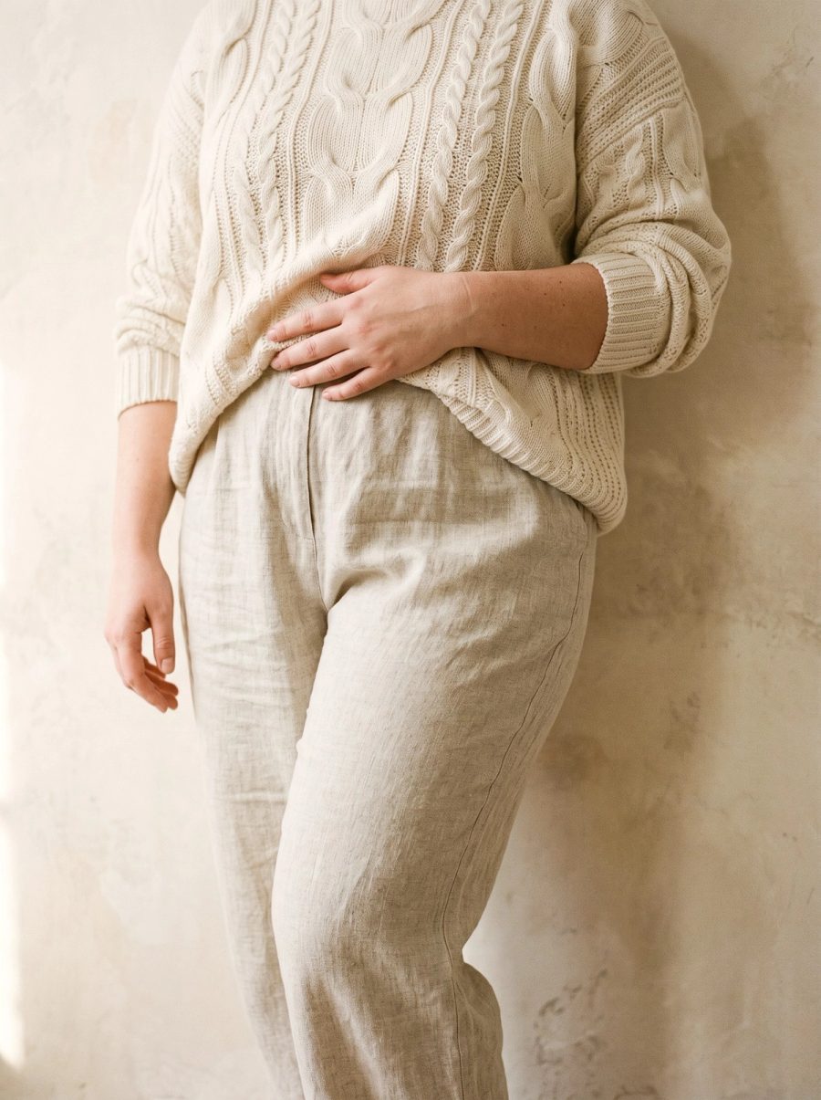 A woman resting a hand over her lower abdomen, where an abdominal pannus hangs over the waistline