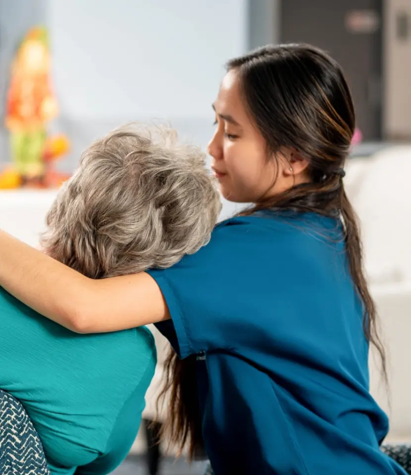young medical aide comforting older woman