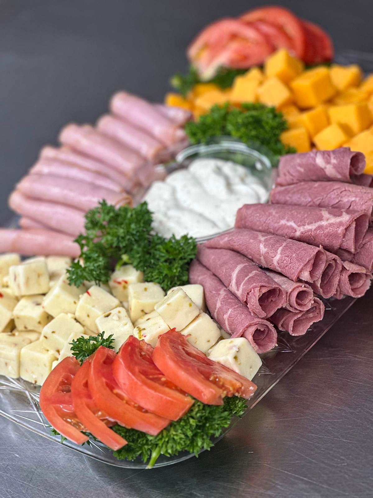delicious tray of assorted meats cheeses and veggies