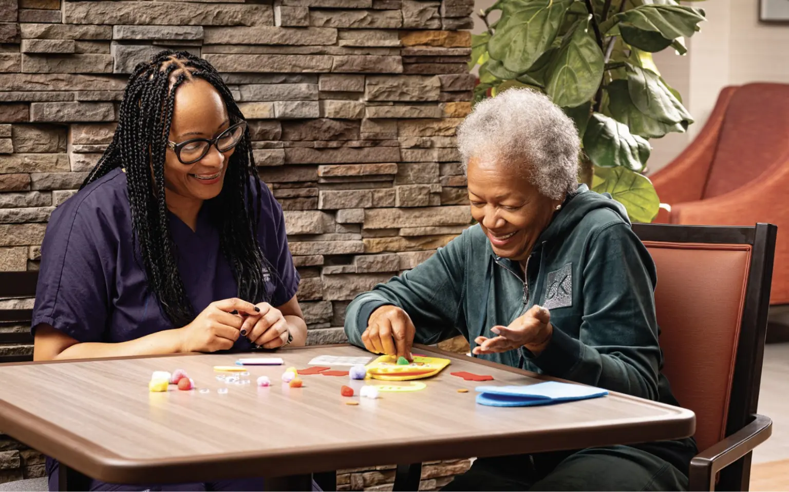older woman with younger aide playing memory games
