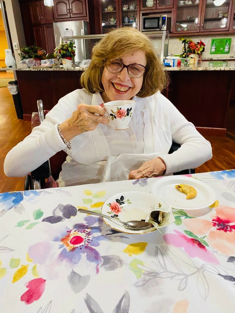 older woman enjoying a cup of tea in a senior living setting
