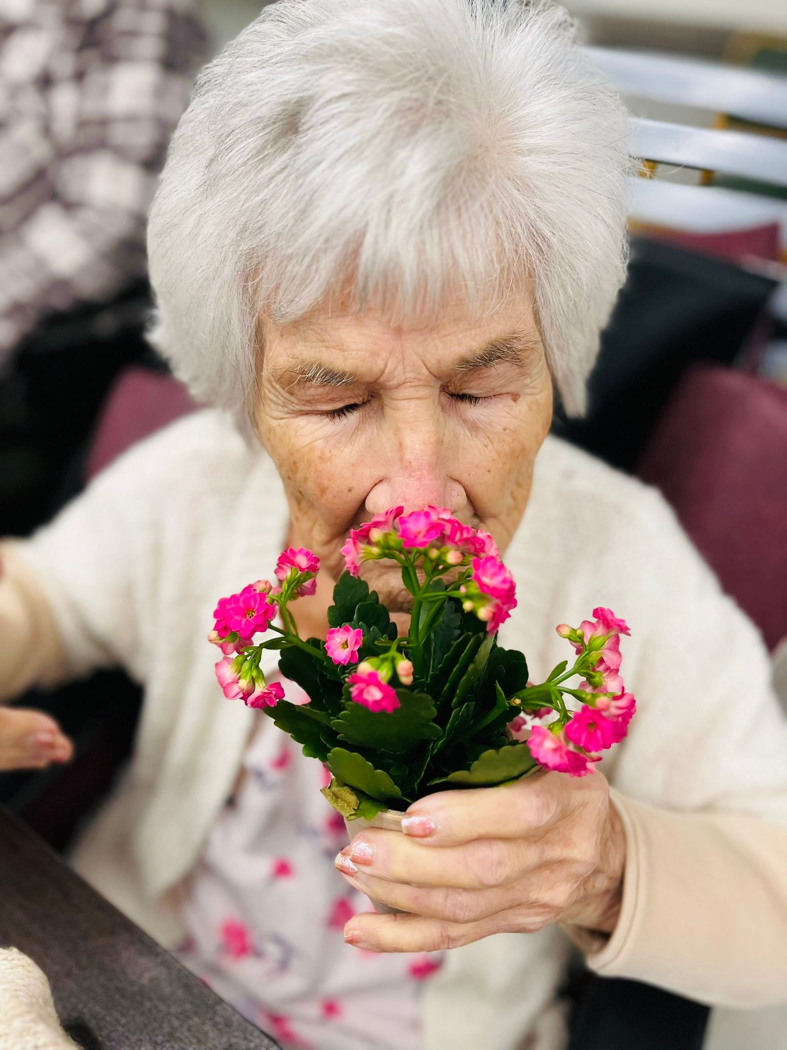 senior woman smelling flowers