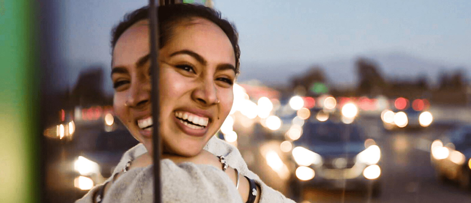 A smiling girl looks out the window of the Roadtrip Nation green RV.