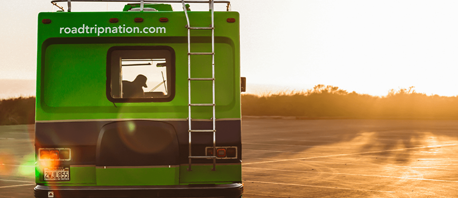 The sun sets in front of the Roadtrip Nation green RV.