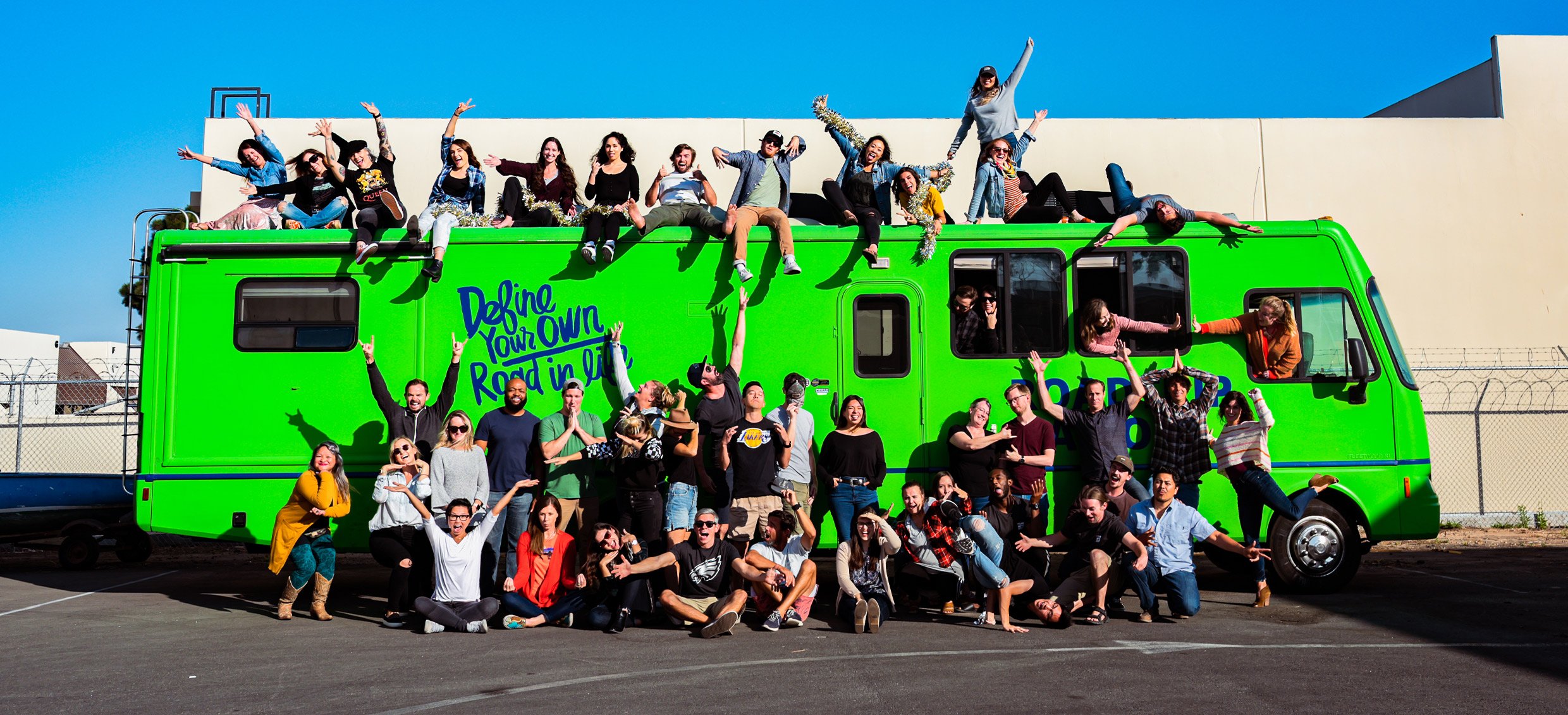 The Roadtrip Nation staff does a goofy pose in front of the green RV.