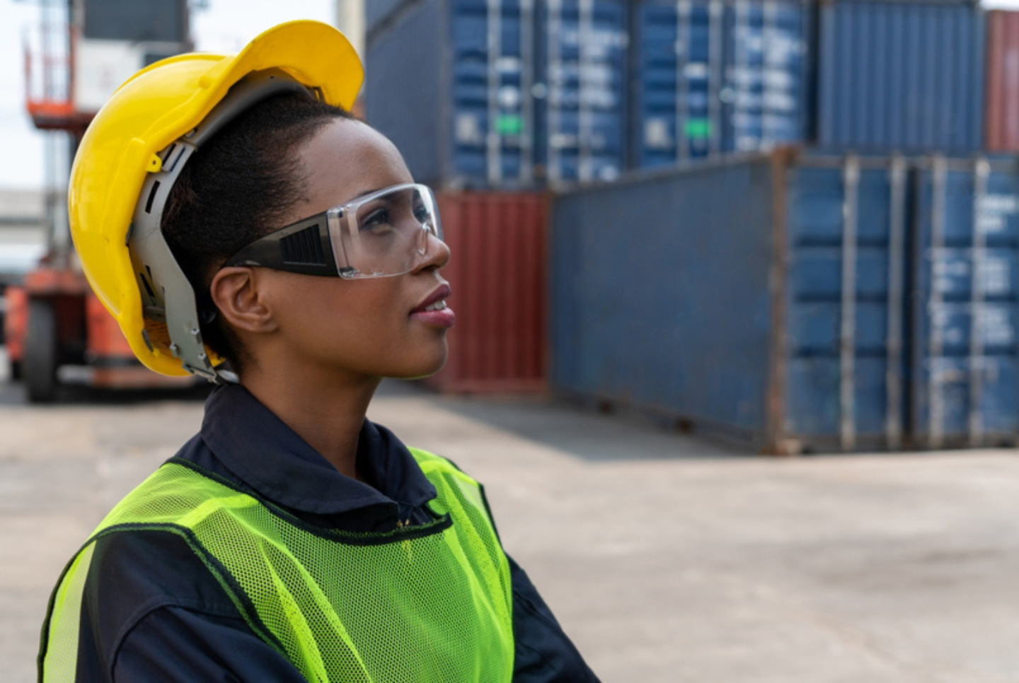Woman standing in shipyard with hardhat and goggles. Women comprise 41% of the supply chain workforce in 2021.