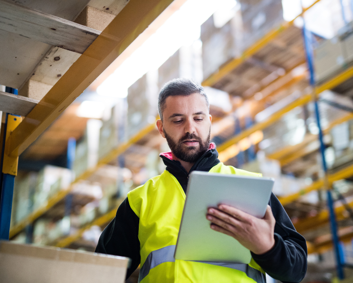 Warehouse worker picking orders from the WMS managed through supply chain integrations. 
