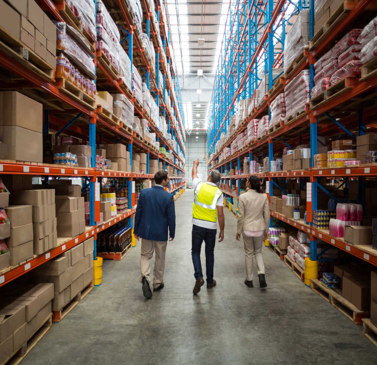 supply chain professionals walking through a warehouse and monitoring inventory