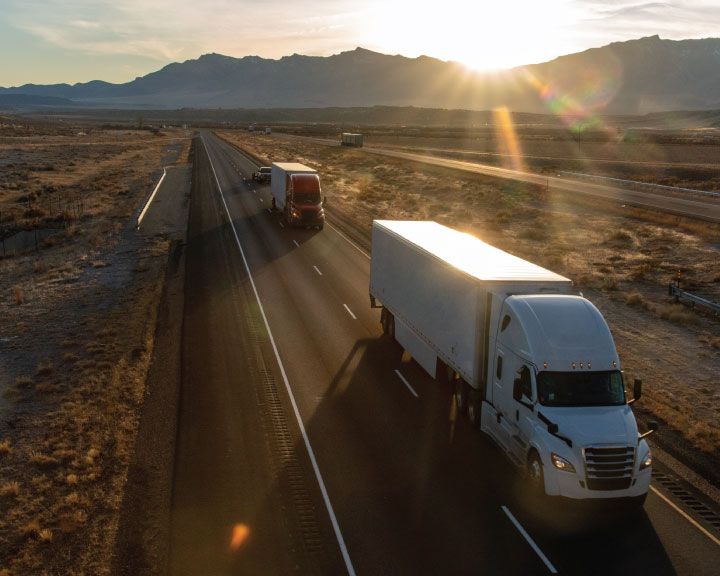 Cargo trucks haul freight on highway.