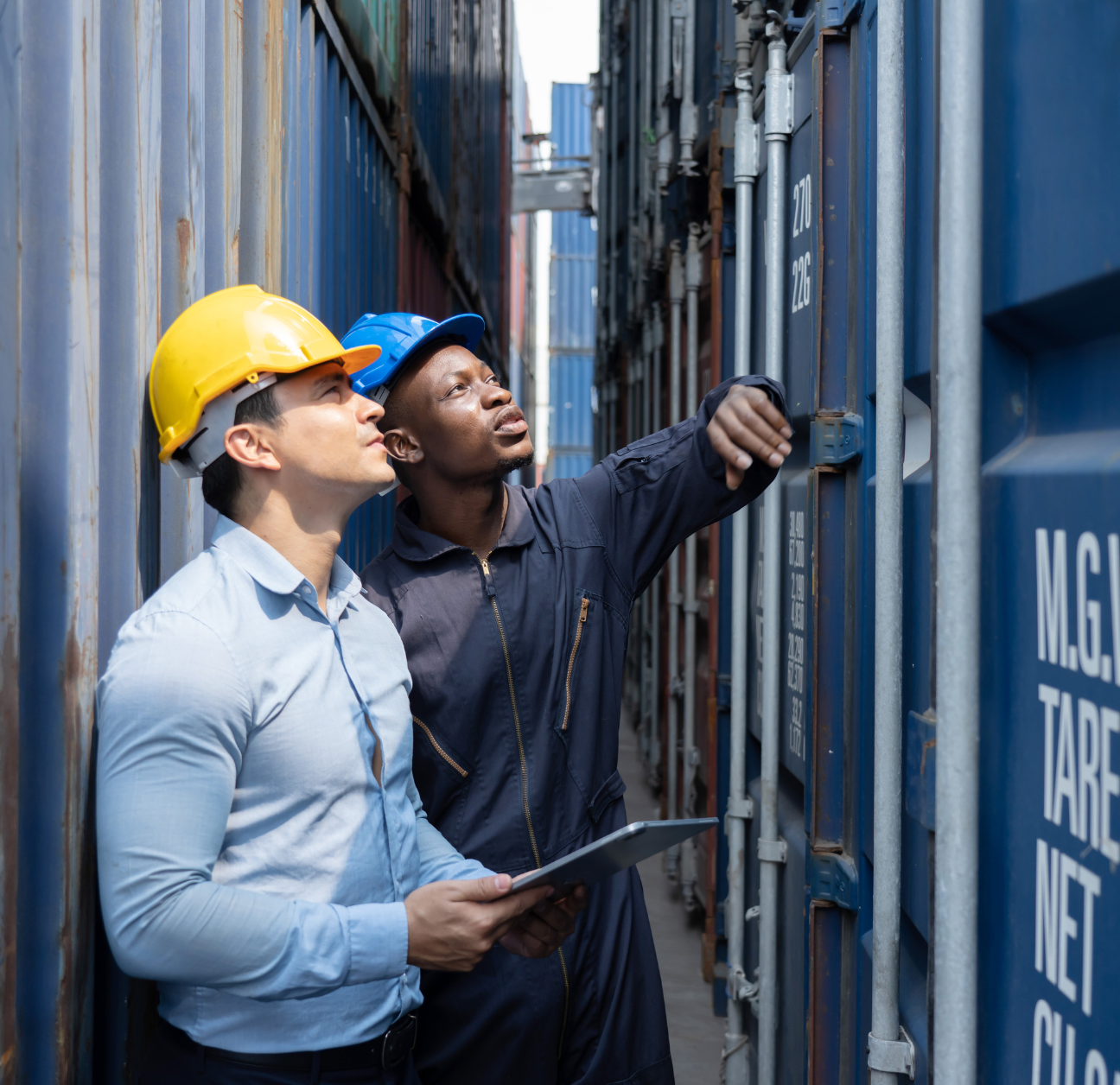 Two supply chain workers monitoring their shipments without the help of supply chain automations. 