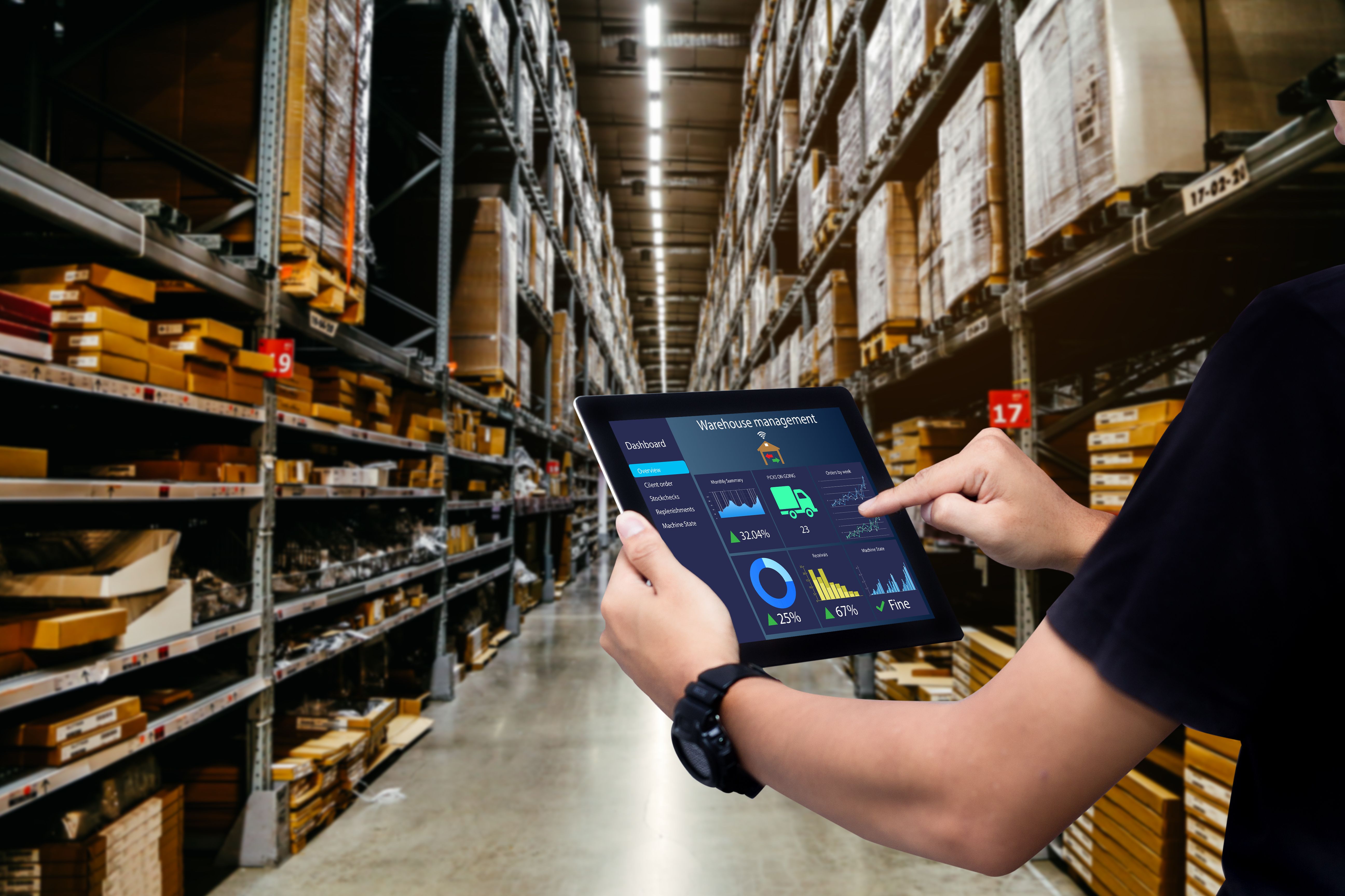 Man holding ipad in warehouse works to Improve sales and margins by integrating your TMS with a leading rate management platform allowing instant quoting and lead conversion.