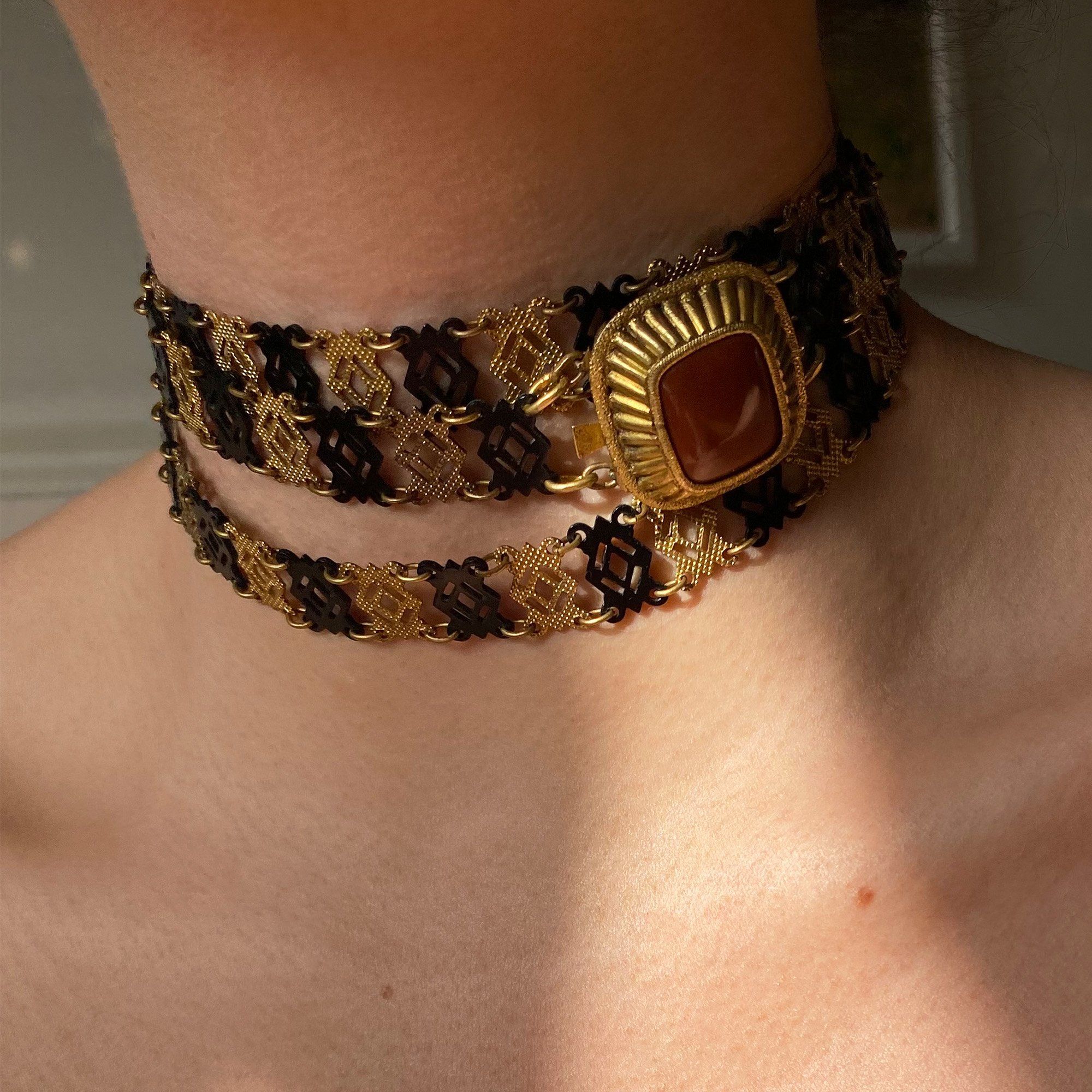 Detail of pinchbeck and black lacquer chain on a neck