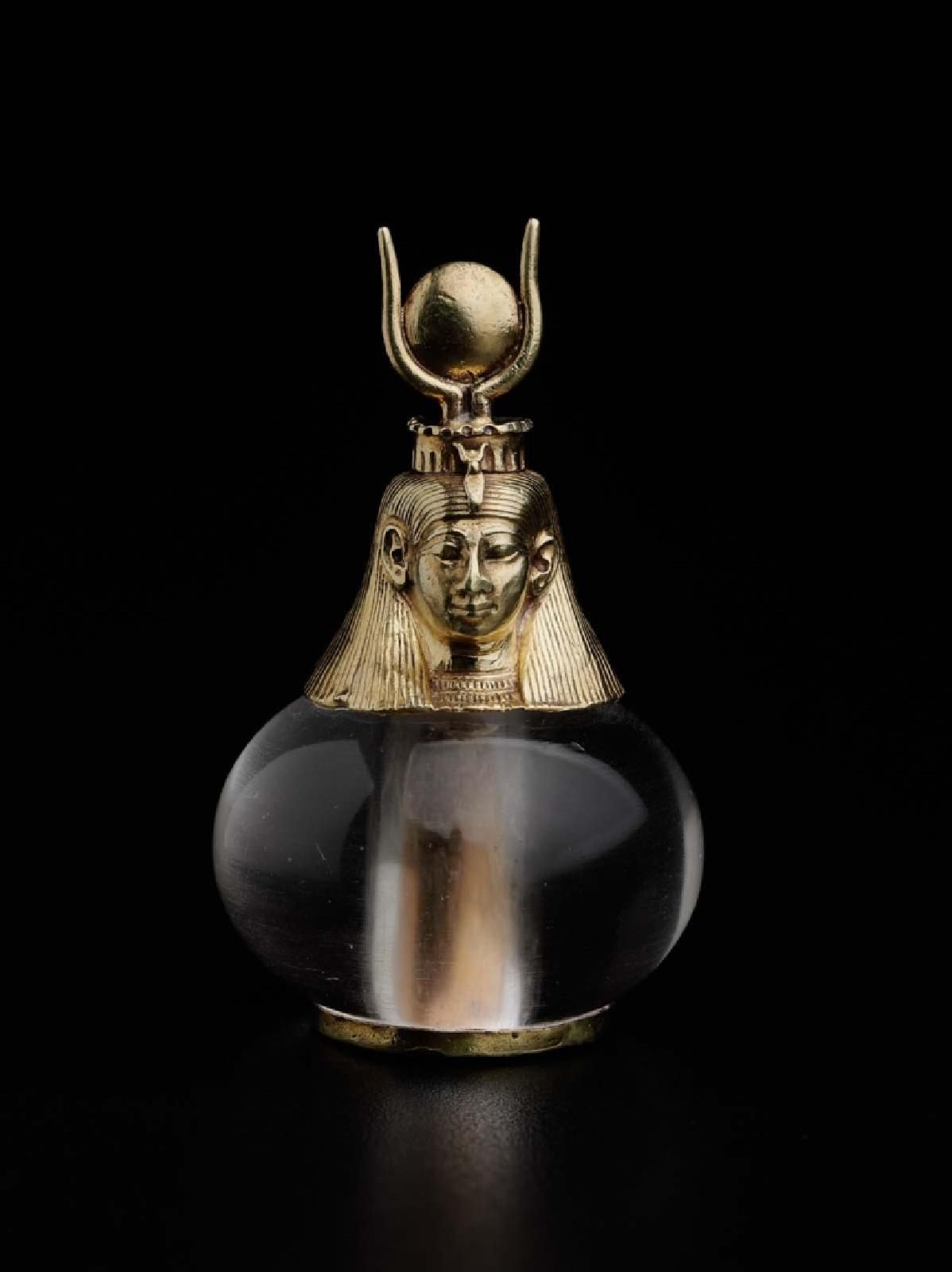 Photograph of Egyptian round crystal container with a gold Hathor headed top.