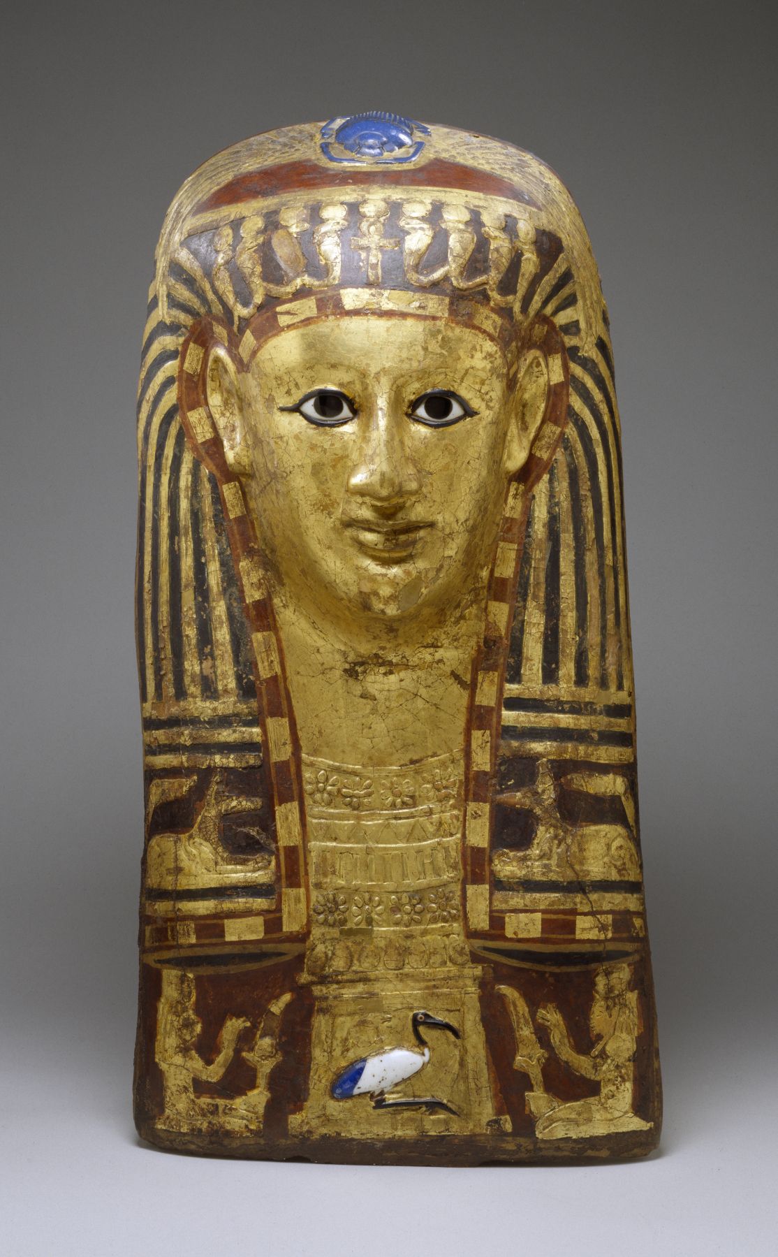 An Egyptian funerary mask with a blue glass scarab - a symbol of renewal - on the top of the head. Cartonnage Mask of a Woman, mid 1st century BCE - mid 1st century CE. The Walters Art Museum.  