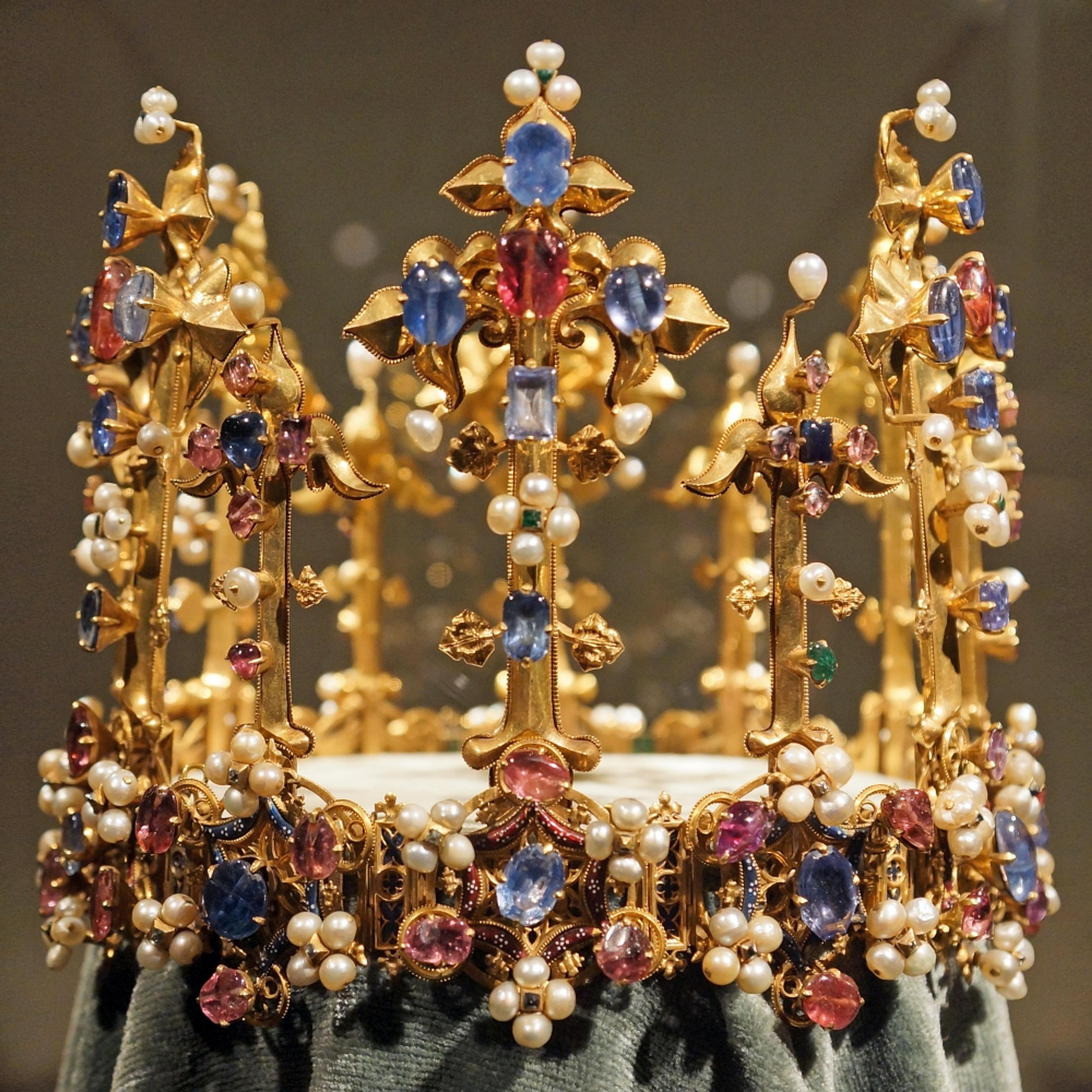 The crown made for the wedding of Anne of Bohemia and Richard II. She died of the plague in 1394. Richard was so devastated that he demolished Sheen Manor, where she died. He designed a monument — a double-tomb for the two of them — with life-sized bronze effegies depicting them crowned and holding hands. Their joint tomb, now damaged, is in Westminster Abbey, 1399. Allie Caulfield/Wikimedia Commons.