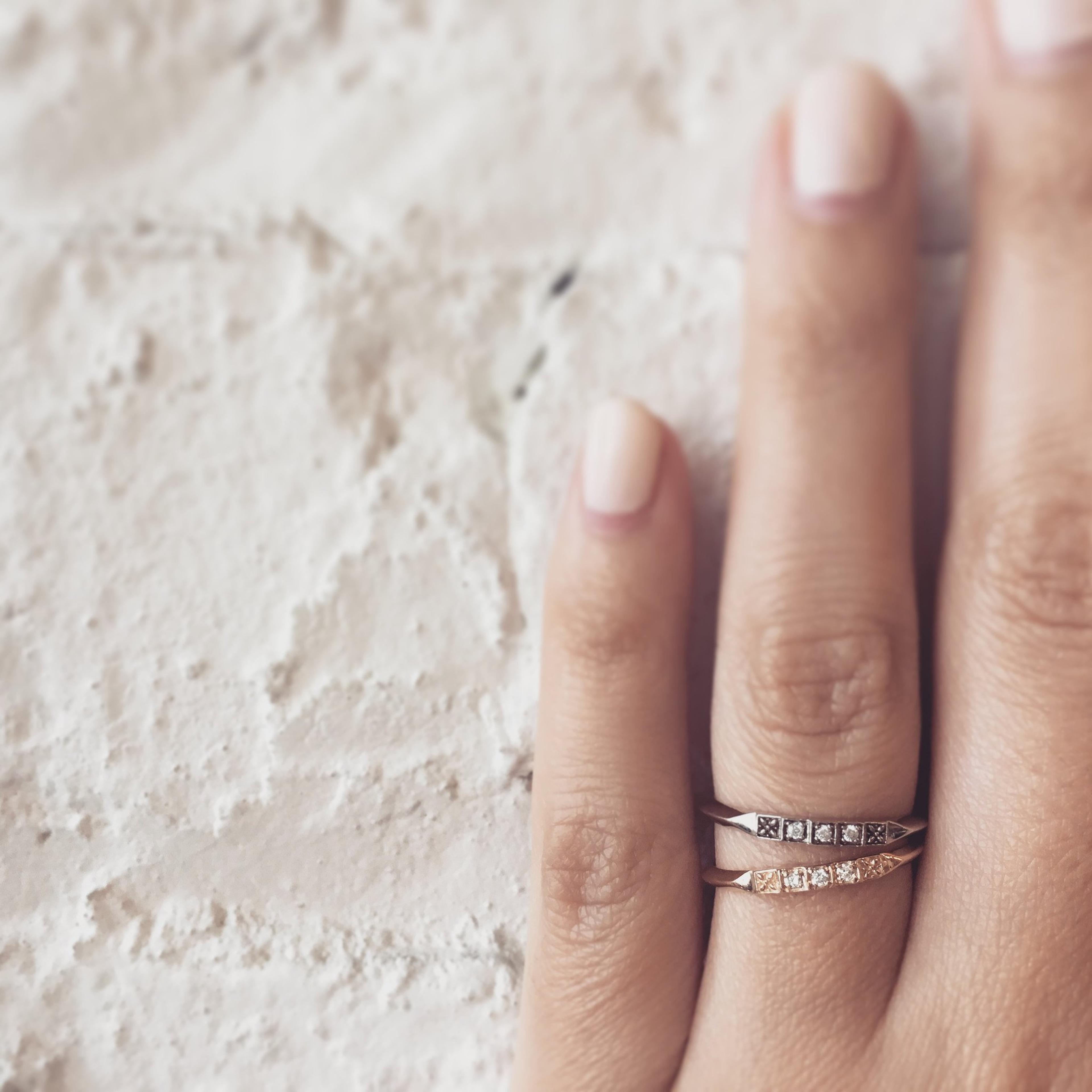 Closeup of a hand wearing two Ziggurat Bands (14k White Gold)