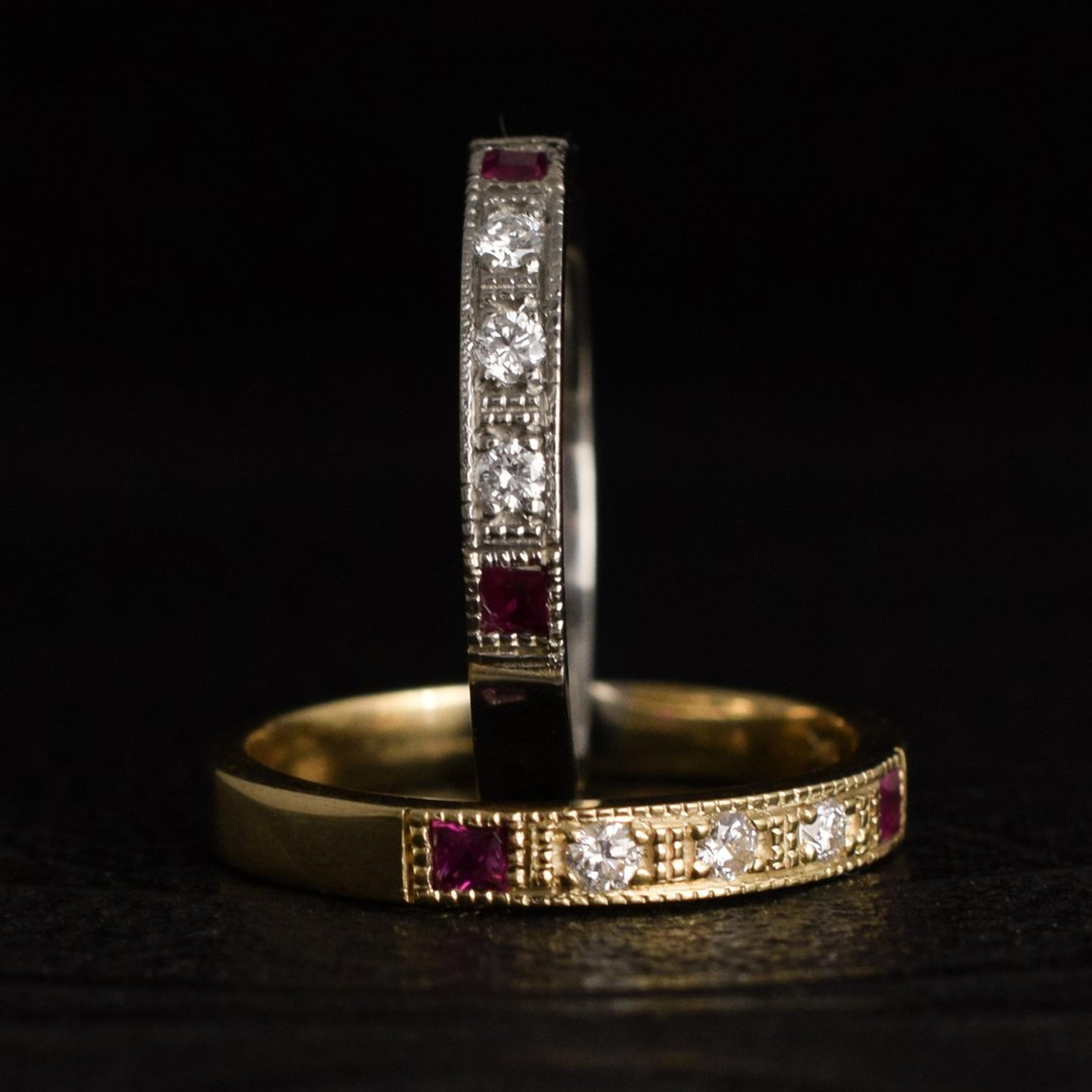Detail of two Esther Rings, one white gold with rubies, one yellow gold with rubies