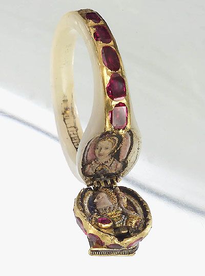 Photograph of Elizabeth I's ring with rubies around the hoop and a hinged locket on the top.
