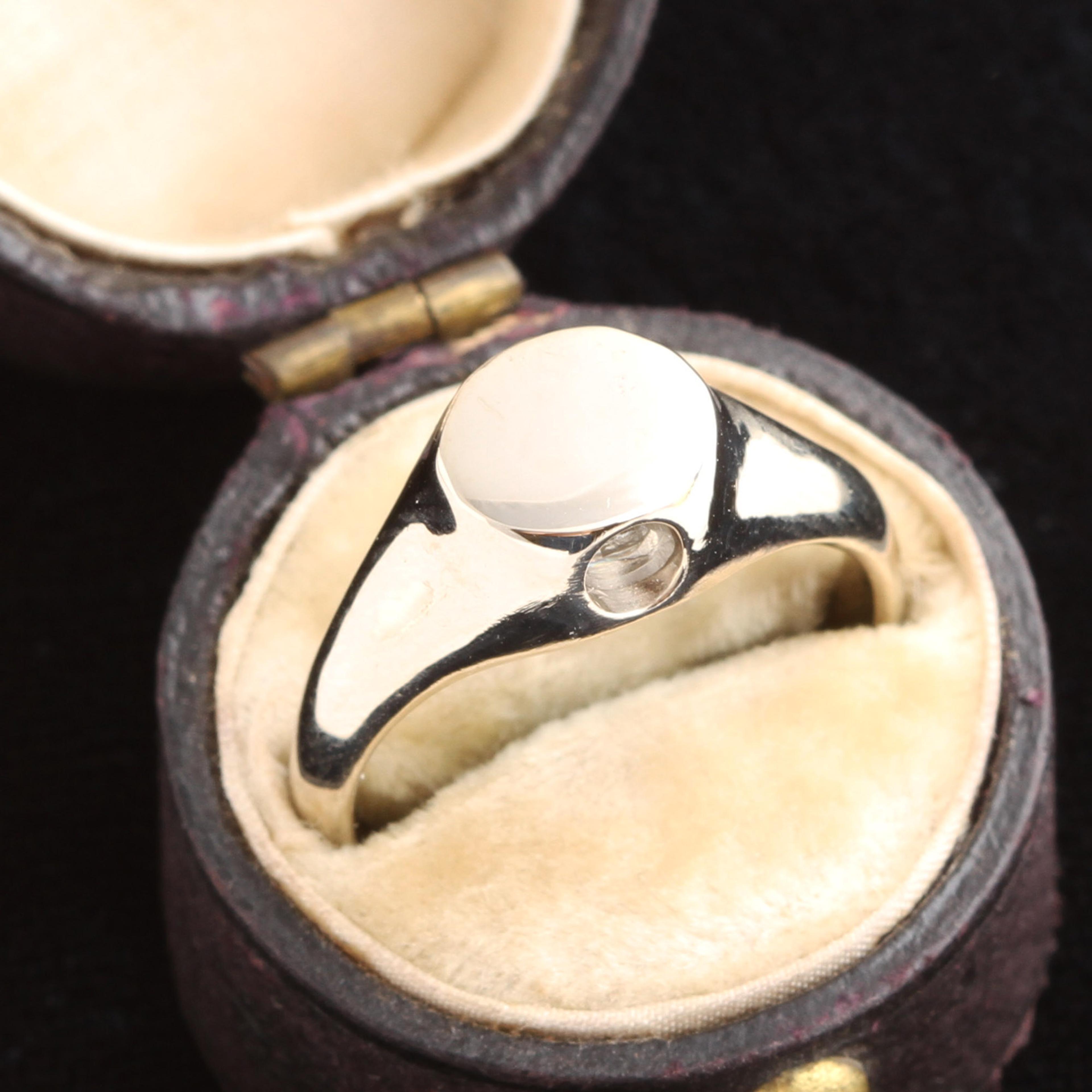 Photo of the white gold peep show ring in an antique box.