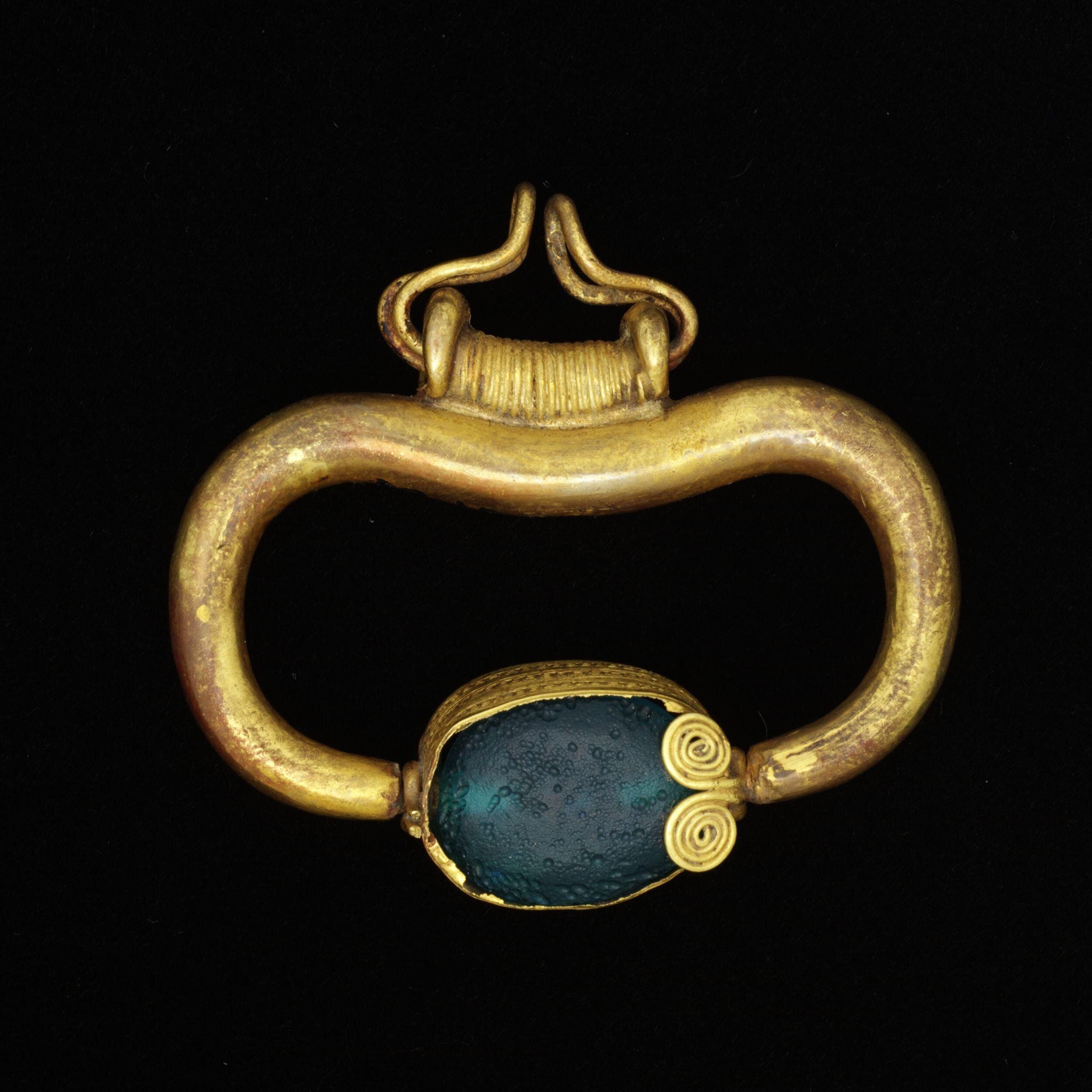 Green glass pendant, 600-500 B.C. The Victoria & Albert Museum.