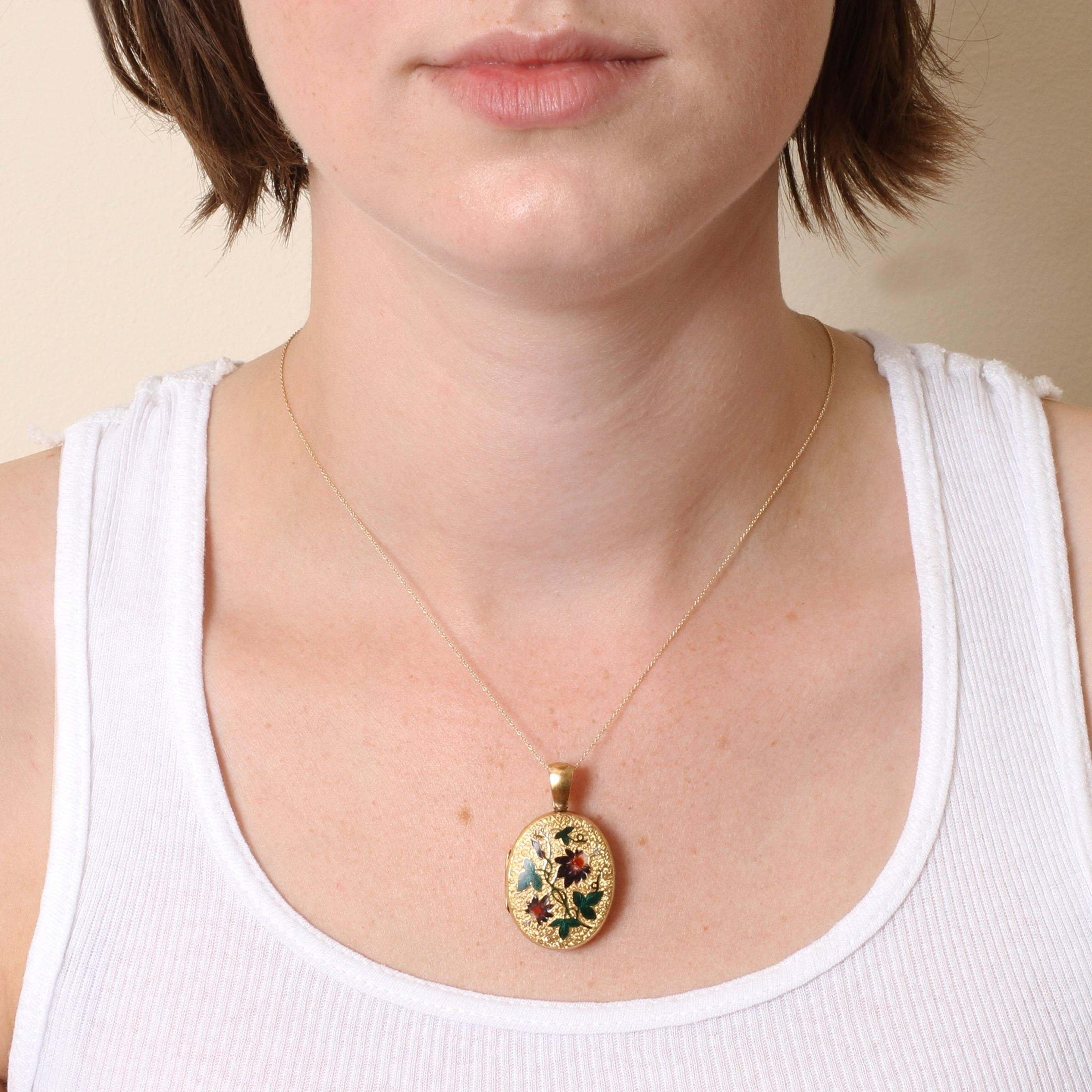 Closeup of Victorian Gold and Enamel Passion Flower Locket worn on a gold chain