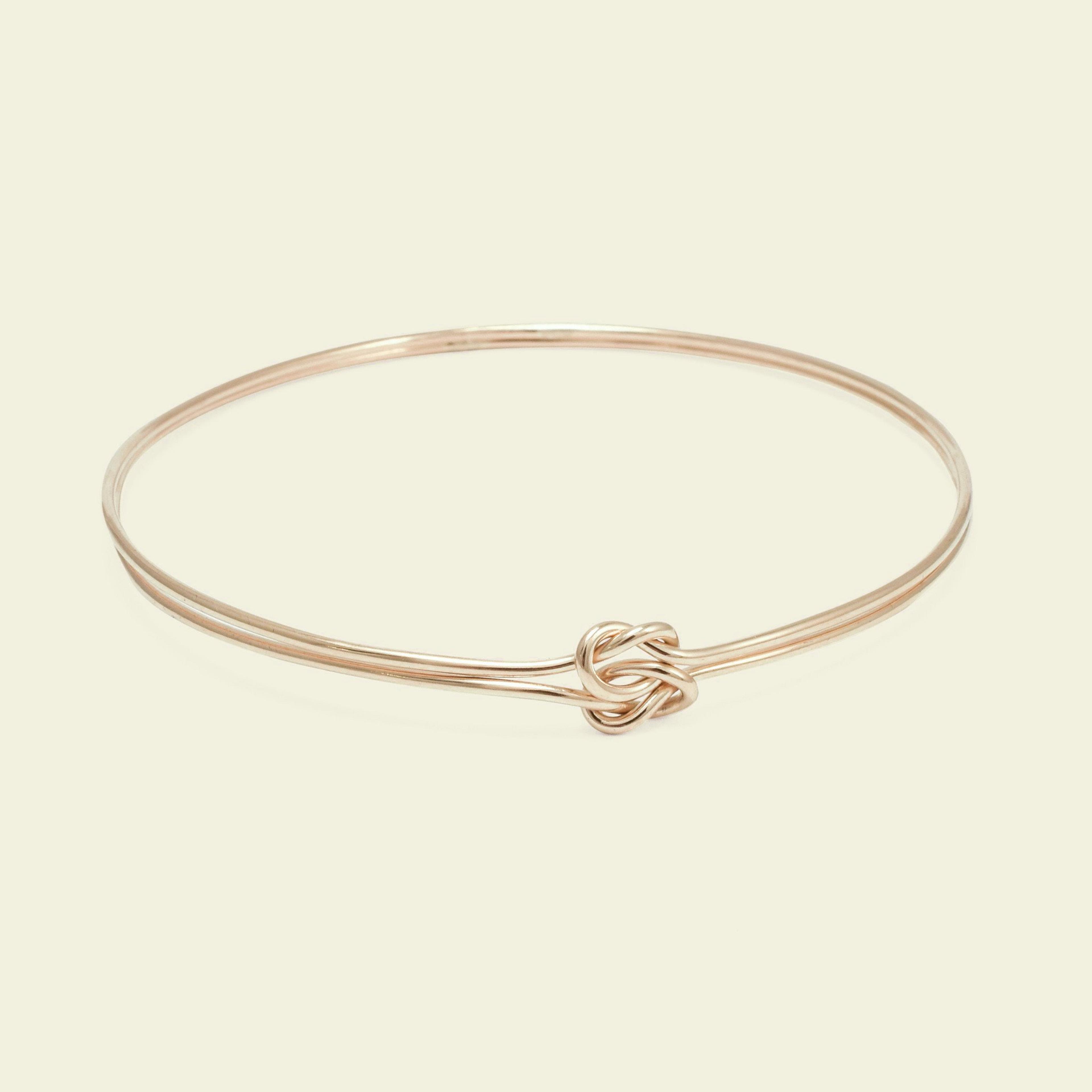 Product photo of a yellow gold lover's knot bracelet