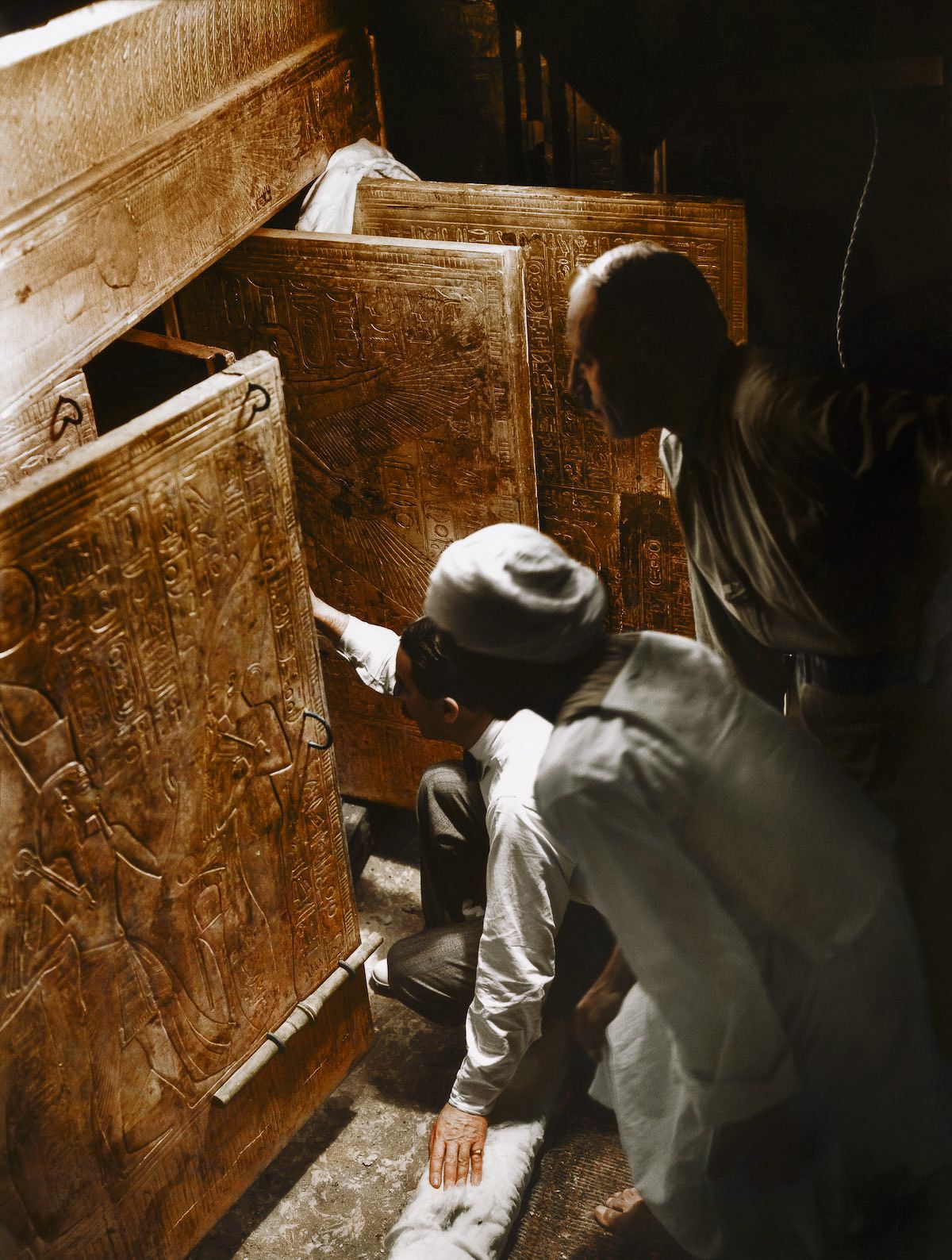 Howard Carter (center) looking inside an Egyptian tomb, colorized by Dynamichrome.