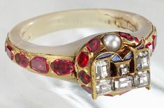 Photograph of Elizabeth I’s ring, a white ring set with rubies on the shank and featuring a locket on the front.