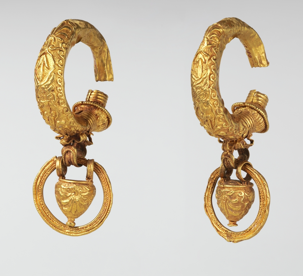 The pendant rings that hang from these hollow gold earrings are thought to have contained perfume. 4th-3rd century B.C., Metropolitan Museum of Art.